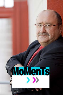A man with glasses and a moustache leaning against a red column.